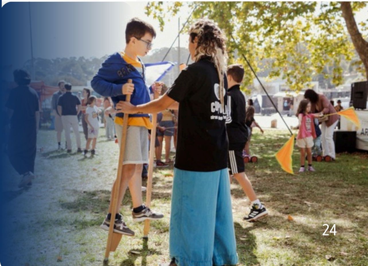 Workshop de circo ao ar livre com crianças a praticar andas